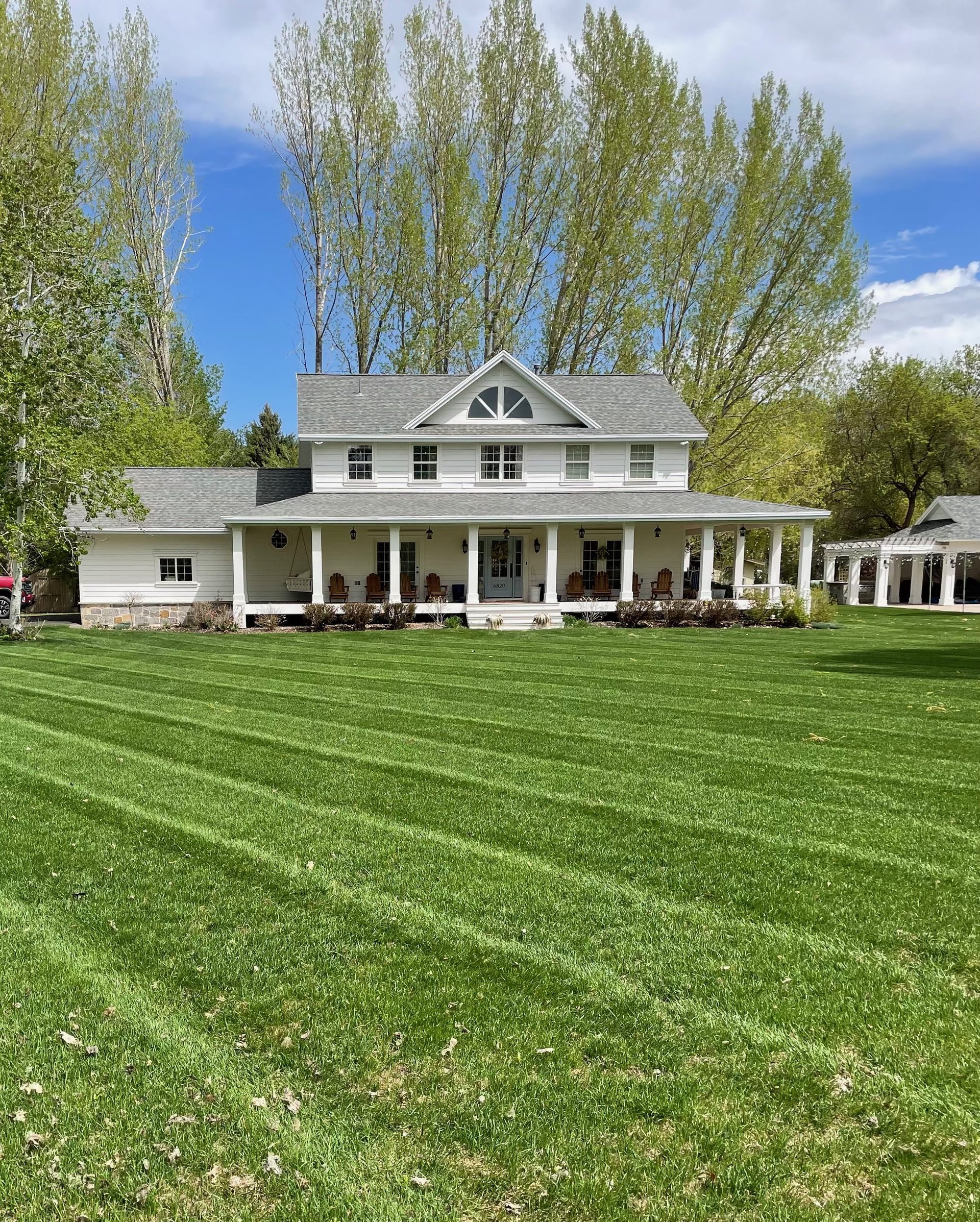White farmhouse with immaculate lawn care — Huntsville Utah